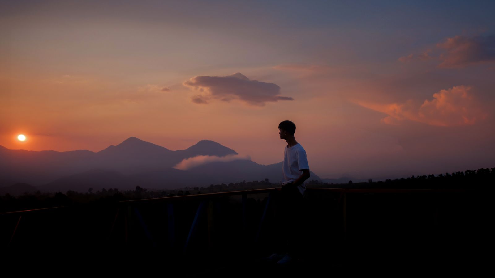 Calm silhouette of a man walking through a mountain valley at sunset, reflecting quiet confidence